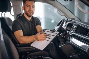 Fulfill the document. Man, is,, sitting in the car, driver photo