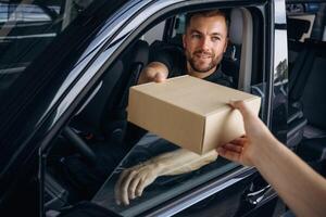 Professional, service. ..Woman is taking her order from delivery man, with the car photo