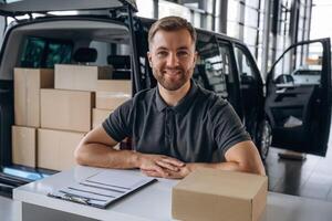 Here's your ,delivery,,. Man loader is near the car with a box photo