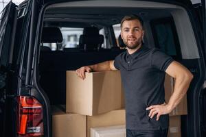 Bunch of ,boxes. ,Delivery man or loader is near the car photo
