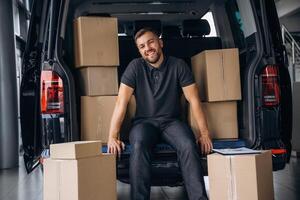 Bunch ,of,, boxes. Delivery man or loader is near the car photo