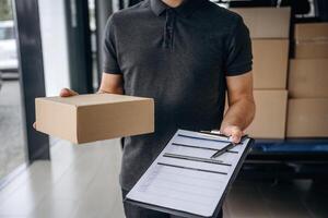 Data in the notepad. Delivery man or loader, is near the car with a box photo