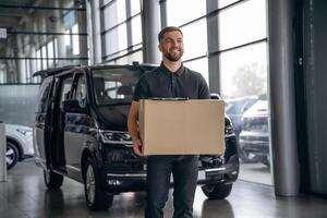 Fast delivery ,service,,, standing. Man loader is near the car with a box photo