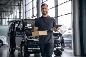 Fast ,delivery service,, standing. Man loader is near the car with a box photo