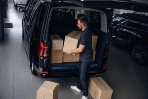 Unloading ,,,the boxes. Delivery man or loader is near the car photo