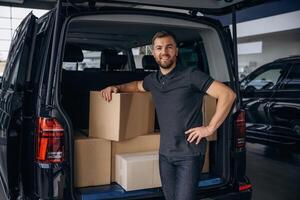 Unloading the,, boxes. Delivery man or loader is near the car photo