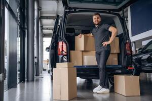 Bunch, of boxes. Delivery man or loader is near the car photo