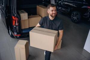 Unloading, the boxes. Delivery man or loader is near the car photo