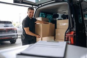 Delivery, man or loader is near the car with a box photo
