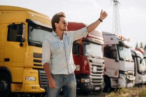 Friendly hand gesture. Truck driver, is, near ,the transport outdoors photo