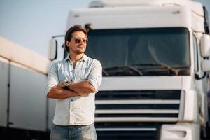 Eyewear, cool look ,in ,,the sunglasses, standing. Truck driver is near the transport outdoors photo