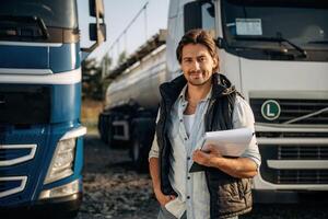 Black notepad, ,,standing and holding it. Truck driver is near the transport outdoors photo