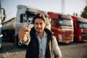 Tool in hand. Truck ,,driver ,is near the transport outdoors photo