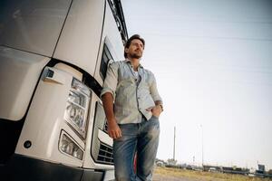 View,, from below, standing ,and posing. Truck driver is near the transport outdoors photo