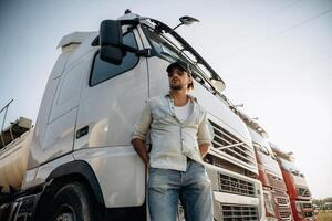 View from, below, ,standing and posing. Truck driver is near the transport outdoors photo