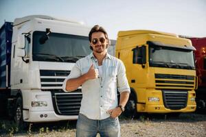 Thumb, up, standing. Truck driver is near the transport outdoors photo
