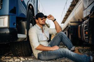 Sitting, on, the ground. Truck driver is near the transport outdoors photo