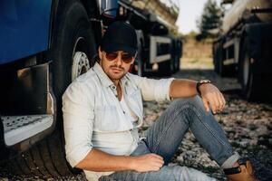Sitting ,on,, the ground. Truck driver is near the transport outdoors photo