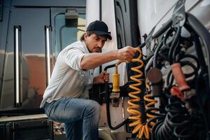 Messing with ,cables, installation, fix. Truck driver is near the transport outdoors photo