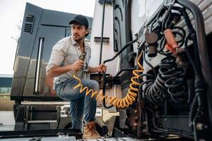 Messing,, with cables, installation, fix. Truck driver is near the transport outdoors photo