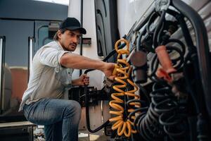 Messing, with ,cables, installation,, fix. Truck driver is near the transport outdoors photo