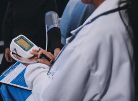 A doctor is using an electronic device to measure blood pressure photo