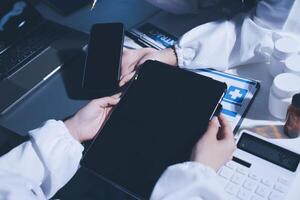 A doctor holding a tablet computer and a laptop photo