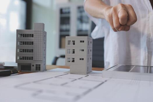 A person is pointing at a model of a building photo