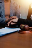 Lawyer and client holding hands over a desk photo