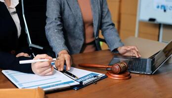 Two business people at a desk with a laptop and a gavel photo