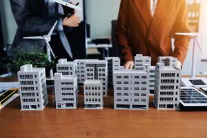 Two people are standing next to model buildings photo