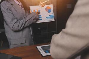 A man and woman are standing in front of a table with a chart on it photo