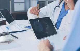 A doctor is looking at a tablet computer screen photo