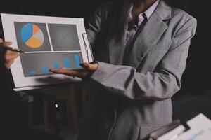 A woman in a business suit holding a tablet with graphs and charts photo
