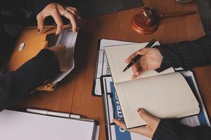 Two business people sitting at a table with a pen and papers photo