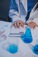 A woman in a lab coat is using a calculator photo