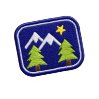 Rectangular embroidered patch features mountain scene with two green trees and yellow star on blue background, symbolizing adventure and nature png