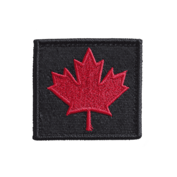 rouge érable feuille est brodé sur noir en tissu correctif, symbolisant Canada. pièce Caractéristiques simple, audacieux conception avec rectangulaire forme, adapté pour Vêtements ou accessoires png