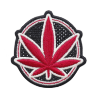 Red and white embroidered patch features stylized leaf design, set against black circular background with dotted pattern. patch has bold and striking appearance png