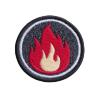 Round embroidered patch features red and yellow flame design on transparency background, symbolizing energy or fire. patch is bordered with white and black edge, adding contrast png