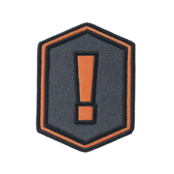 Fabric patch with orange exclamation mark on dark gray background, outlined in orange, conveys sense of urgency or alert. patch has hexagonal shape and textured surface png