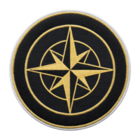 Circular embroidered patch features gold compass rose design on transparency background, symbolizing navigation and exploration. patch is bordered with thin white edge, adding contrast png