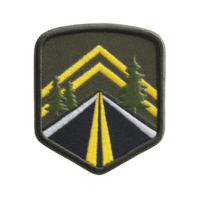 Road patch design features highway with yellow lines flanked by green trees, set against transparency background. patch has shield shape with embroidered details, evoking sense of adventure png