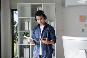 Graphic Designer Analyzing Color Graphs in Modern Office with Digital Tablet and Headphones photo