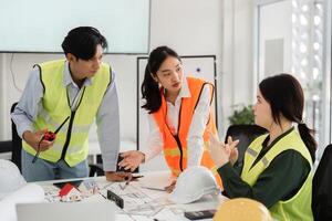 Construction team in safety vests engaged in detailed discussion of building plans in modern office photo