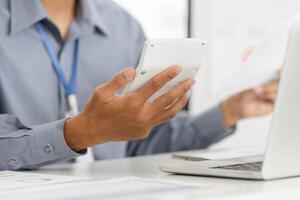 Remote Work and Digital Transformation. Business professional using calculator and documents. photo