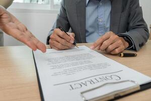 Contract Signing and Agreement. Close-up of a businessman signing a contract in a professional setting. photo
