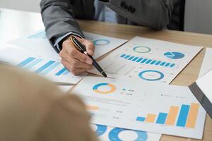 Business Analysis in Progress. A businessman pointing at financial data during a corporate meeting. photo
