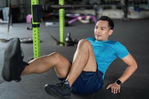 Fitness. Man Doing Bicycle Crunches in Gym Environment photo