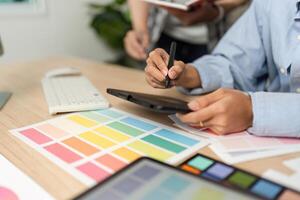 Creative Process in UX and UI Design. Designer working on a tablet with color swatches. photo